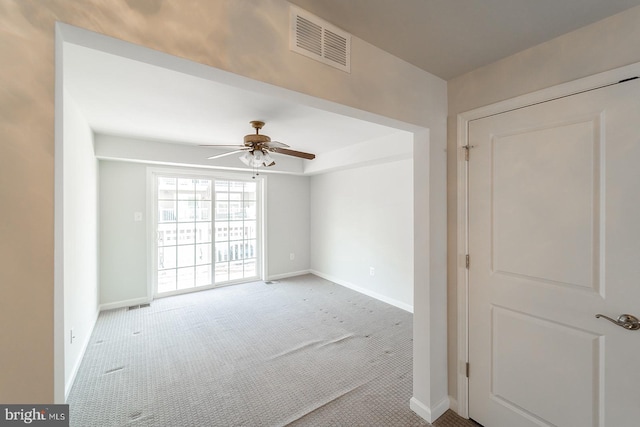 spare room featuring visible vents, carpet flooring, baseboards, and ceiling fan