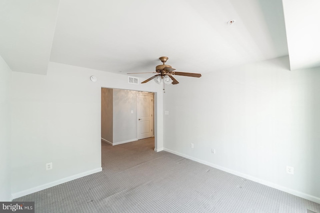 spare room with visible vents, baseboards, light colored carpet, and ceiling fan