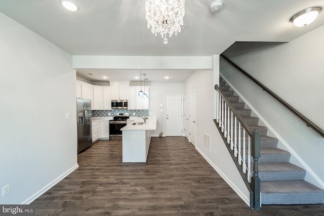 kitchen featuring tasteful backsplash, light countertops, dark wood-style floors, white cabinets, and stainless steel appliances