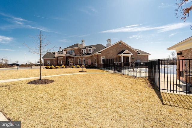 view of front facade featuring fence and brick siding