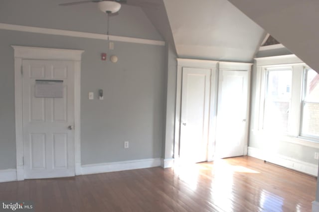 interior space with vaulted ceiling, wood finished floors, and baseboards