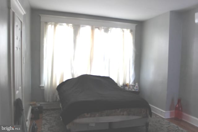 bedroom featuring dark wood finished floors and baseboards