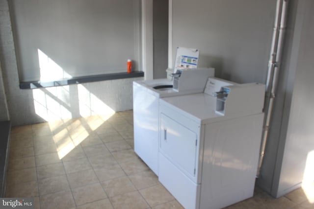 community laundry room featuring light tile patterned flooring and washer and dryer