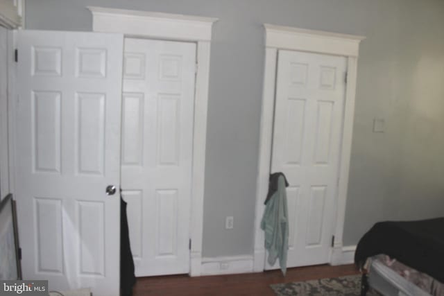 bedroom featuring baseboards and dark wood-style flooring