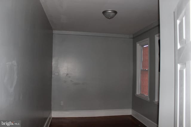 unfurnished room featuring dark wood-style floors and baseboards