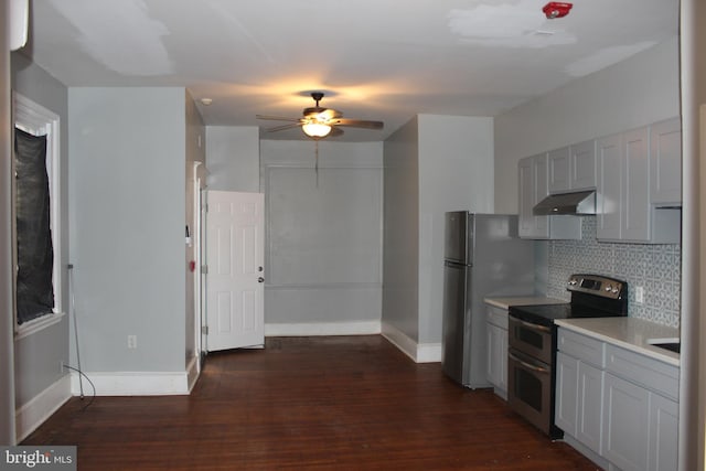 kitchen with backsplash, ventilation hood, dark wood-type flooring, light countertops, and range with two ovens