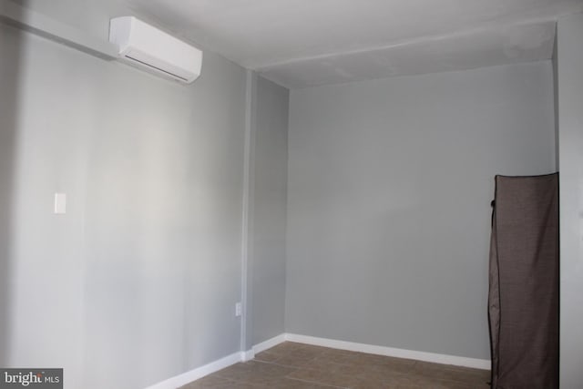 unfurnished room with baseboards and a wall mounted AC