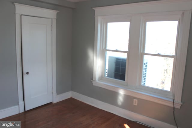 empty room with dark wood-style floors and baseboards