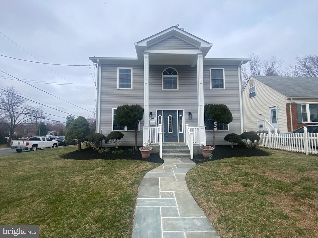 greek revival house with a front yard and fence