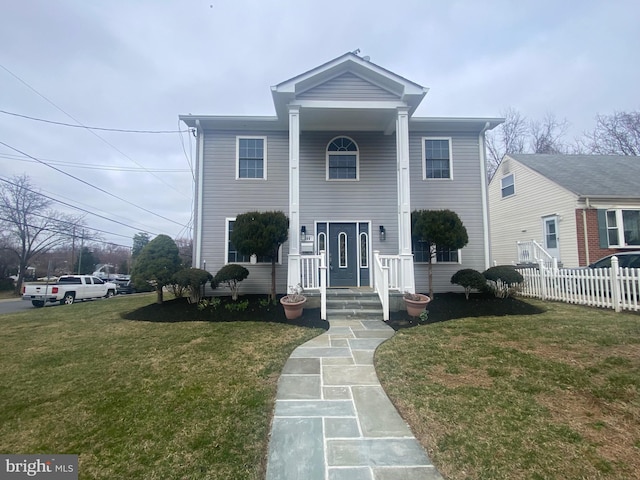 greek revival house with a front yard and fence