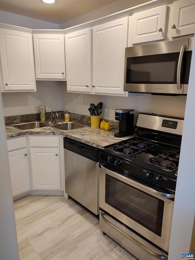 kitchen with white cabinets, appliances with stainless steel finishes, and a sink