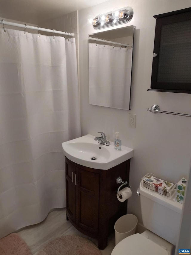 bathroom with a shower with shower curtain, toilet, and vanity