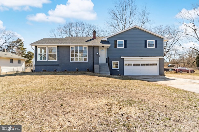 split level home featuring fence, driveway, an attached garage, a chimney, and brick siding