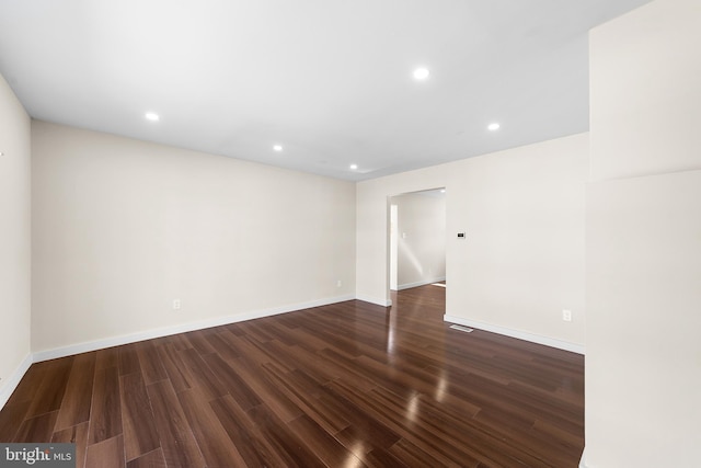 empty room featuring dark wood-style floors, recessed lighting, and baseboards