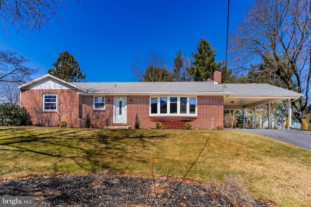 single story home featuring driveway, a chimney, a carport, a front lawn, and brick siding