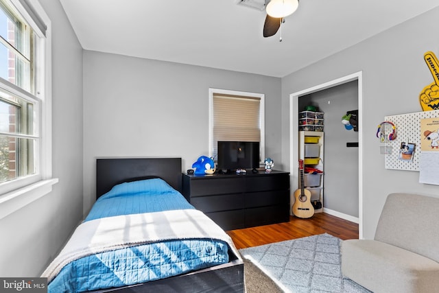 bedroom featuring ceiling fan, baseboards, and wood finished floors