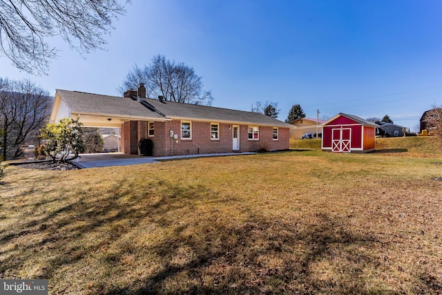 rear view of house with an attached carport, an outbuilding, a shed, a yard, and brick siding