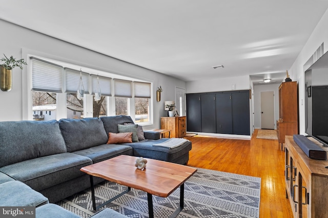 living room with visible vents and light wood-style flooring