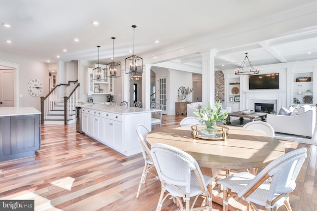 dining room with recessed lighting, stairway, a high end fireplace, and light wood finished floors