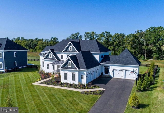 view of front facade featuring a front lawn, a standing seam roof, aphalt driveway, an attached garage, and metal roof