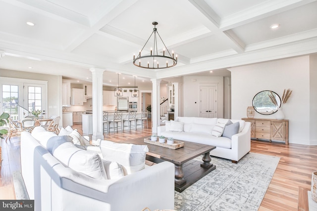 living room with light wood-style flooring, coffered ceiling, beamed ceiling, and ornate columns