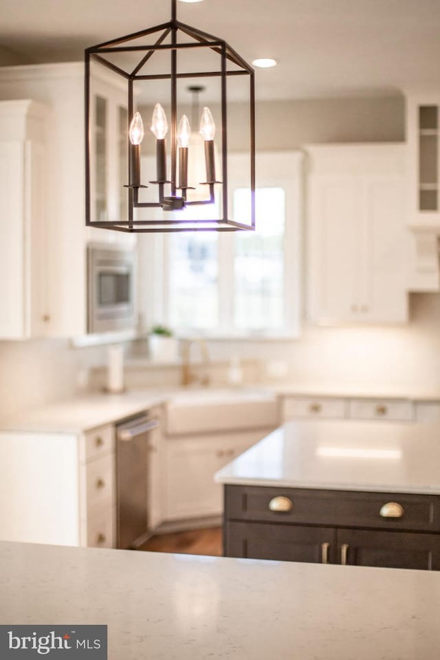 kitchen featuring white cabinetry, a notable chandelier, glass insert cabinets, and stainless steel dishwasher