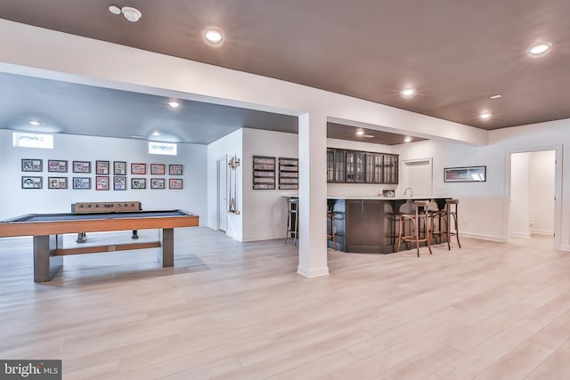 recreation room featuring indoor wet bar, recessed lighting, light wood-type flooring, and baseboards