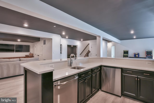 kitchen with open floor plan, light countertops, stainless steel dishwasher, fridge, and a sink