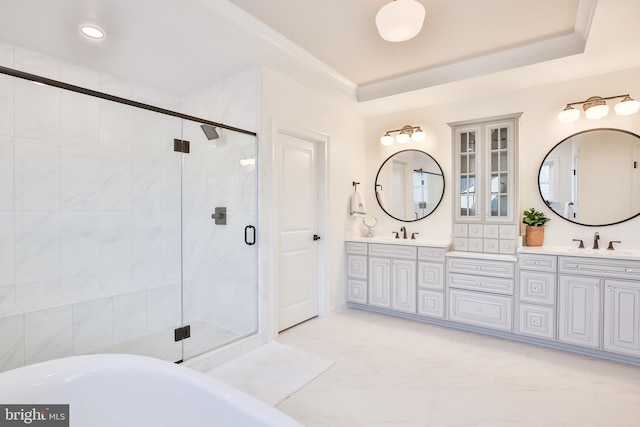 full bath with double vanity, a soaking tub, a shower stall, and a sink