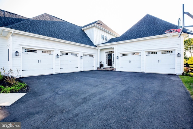 view of front of house with aphalt driveway, a garage, and a shingled roof