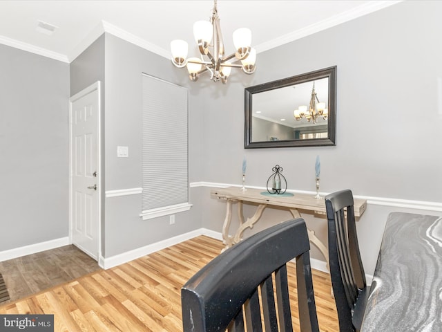 foyer entrance with baseboards, an inviting chandelier, wood finished floors, and ornamental molding