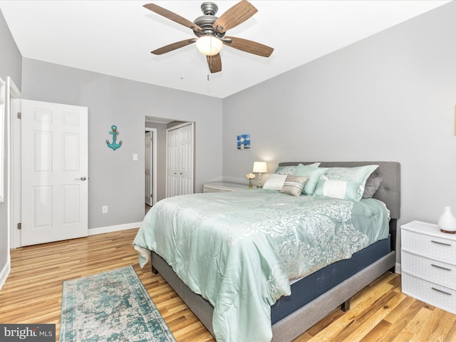 bedroom featuring a ceiling fan, wood finished floors, baseboards, and a closet