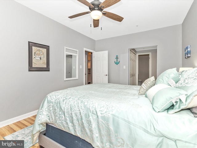 bedroom with a ceiling fan, baseboards, and wood finished floors