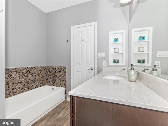 bathroom with ceiling fan, a bath, vanity, and wood finish floors