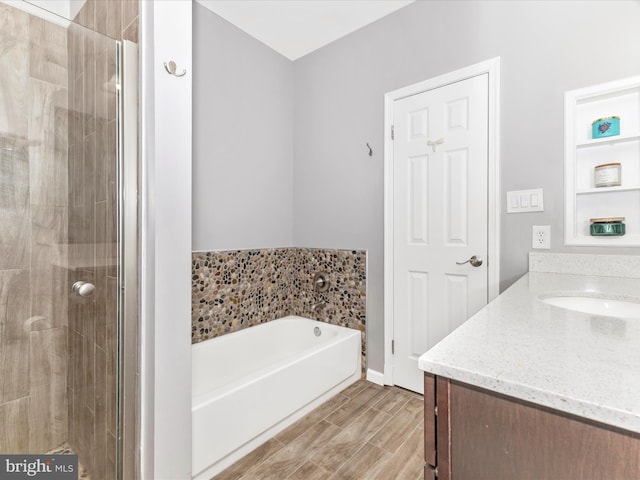 bathroom featuring vanity, a garden tub, a stall shower, and wood finish floors