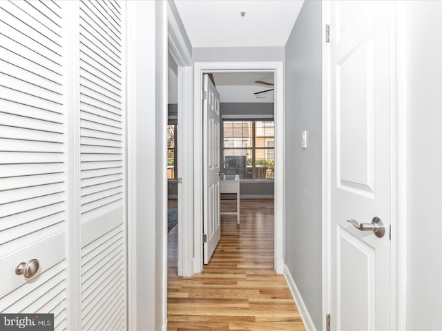 hall featuring light wood finished floors and baseboards