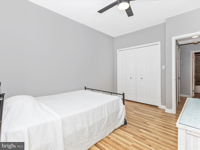 bedroom with a closet, baseboards, light wood-style floors, and a ceiling fan