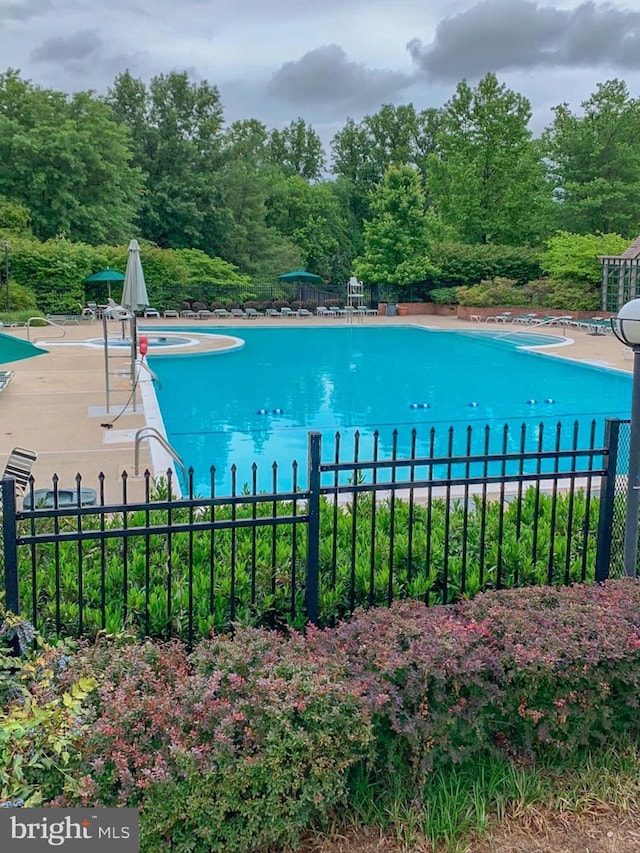 pool with a patio area and fence