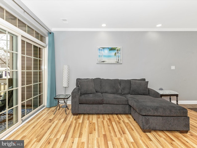 living area with crown molding, wood finished floors, and baseboards