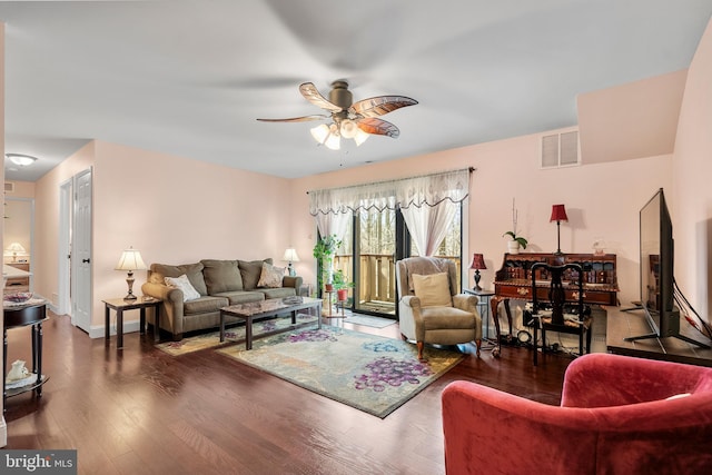 living room with baseboards, wood finished floors, visible vents, and ceiling fan