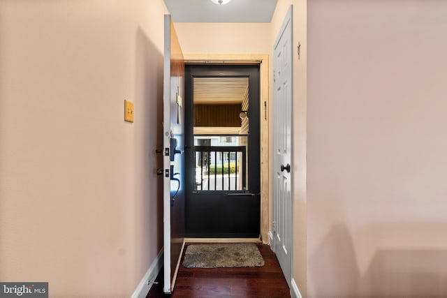 doorway to outside with baseboards and wood finished floors