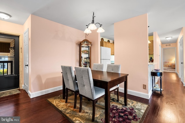 dining room with visible vents, baseboards, and dark wood-style flooring