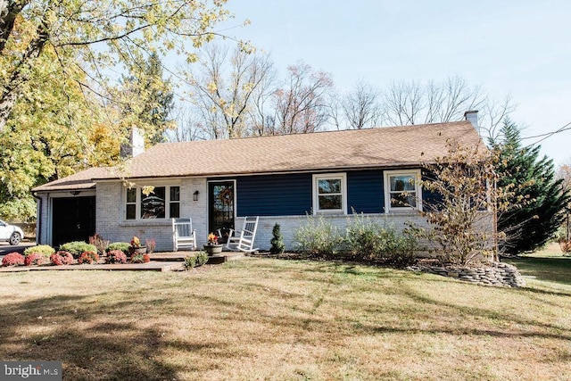 single story home with a front lawn, an attached garage, brick siding, and a chimney