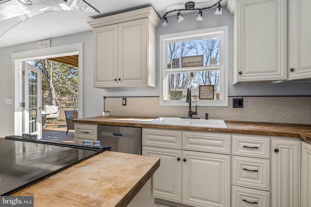 kitchen featuring a sink, wooden counters, dishwasher, and a wealth of natural light