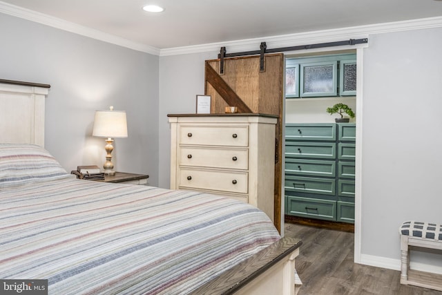 bedroom with baseboards, dark wood finished floors, a barn door, recessed lighting, and crown molding