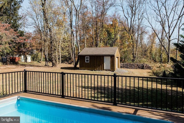 view of swimming pool with a storage shed, a fenced in pool, and an outdoor structure