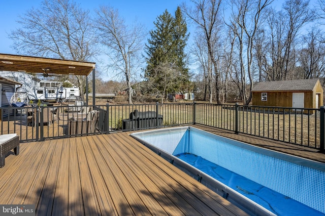 view of swimming pool featuring a deck, an outdoor structure, and outdoor dining space