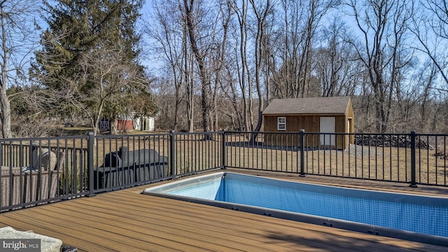 view of pool with a wooden deck and an outdoor structure