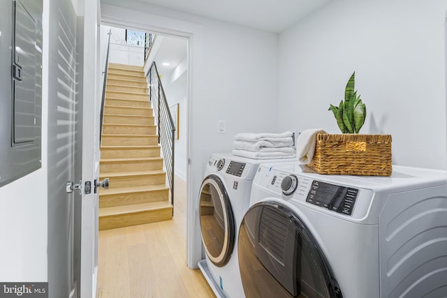 washroom with light wood-style flooring, laundry area, and washing machine and clothes dryer