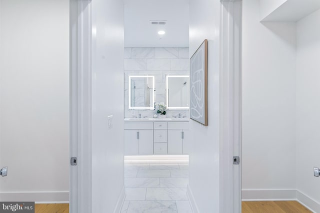 full bathroom featuring double vanity, baseboards, visible vents, and a sink